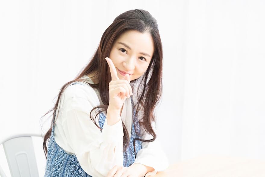 指を立てる女性